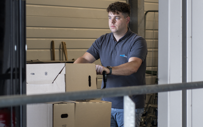 Employé Archiveuro poussant un chariot de cartons